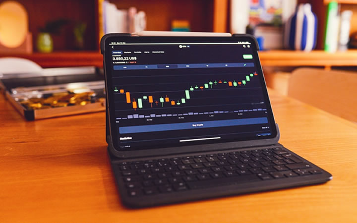 A candlestick chart runs on a laptop