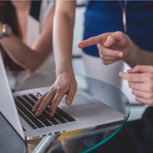 Two people on a laptop discussing resource utilization