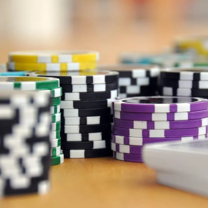 Sets of poker chips and a deck of cards on a table